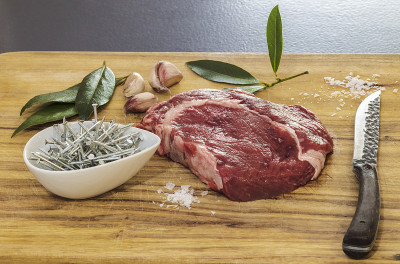 一块红肉，配上香料，刀和一碗金属钉