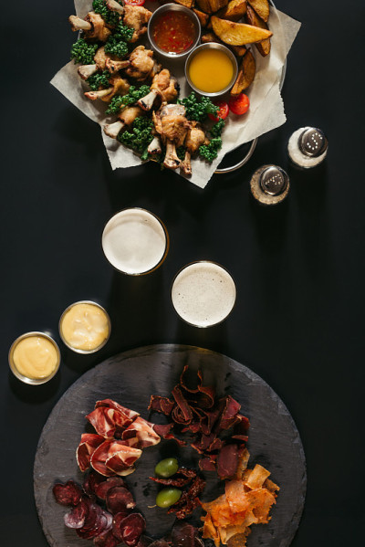 俯视杯啤酒，什物肉和炸土豆鸡黑