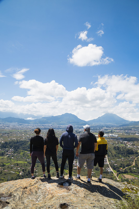 Group of friends standing on top of the mountain l