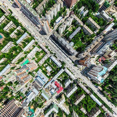 空中城市景观十字路口和道路，房屋，建筑物，公园和停车场。阳光明媚的夏日全景图