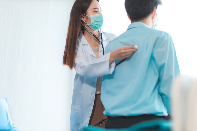 手持医生测量病人的压力。医疗工作者在检查血压或其他健康的年轻人期间。