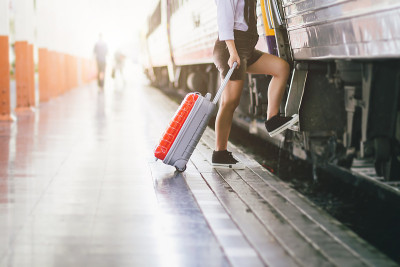 亚洲妇女怀孕的旅客正带着她的红色小推车在火车站旅行。