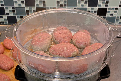 用蒸锅蒸肉排和花椰菜。系列。