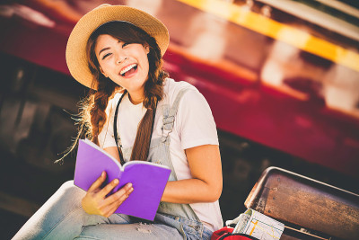 快乐的亚洲年轻女孩旅行背包冒险户外乘火车。