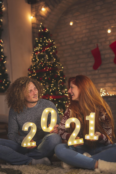 一对夫妇在庆祝新年时手持数字2021