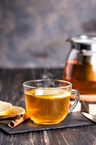 深色木桌上放着一杯热柠檬姜茶。