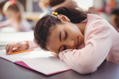 疲惫的女学生在教室里睡觉