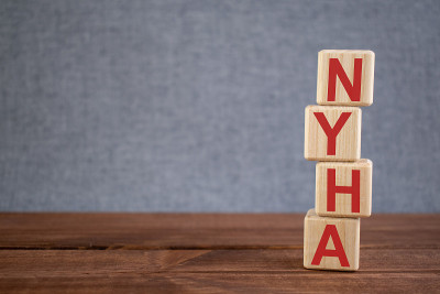 简称NYHA(纽约心脏协会)文本首字母缩写在木制立方体上的深色木制背景上。医学概念。