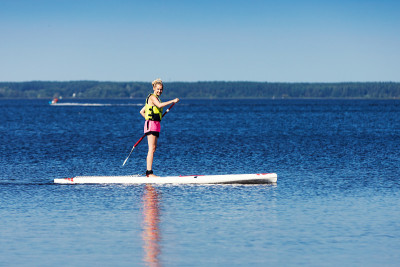 Sup - woman站着在湖里划桨