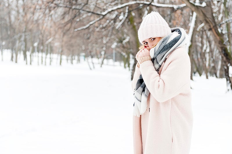 年轻女子在一个满是雪的公园里