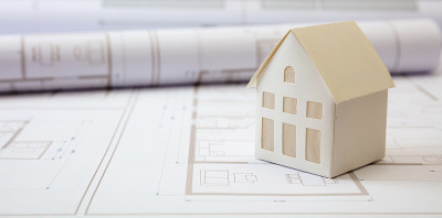 建筑的概念。办公桌上有住宅建筑图纸和建筑房屋模型