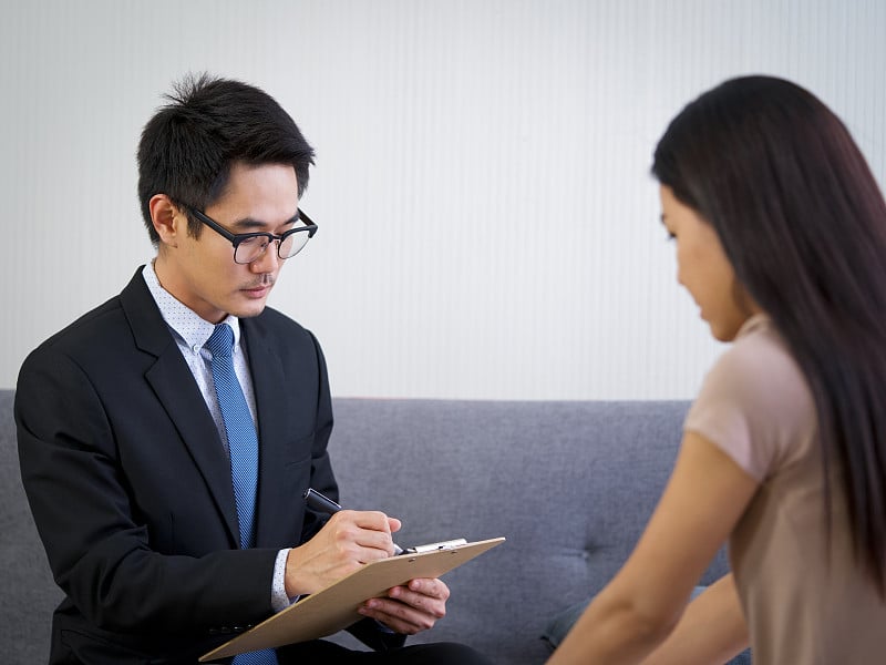 年轻的亚洲精神科医生在医院精神健康服务中心辅导抑郁症妇女