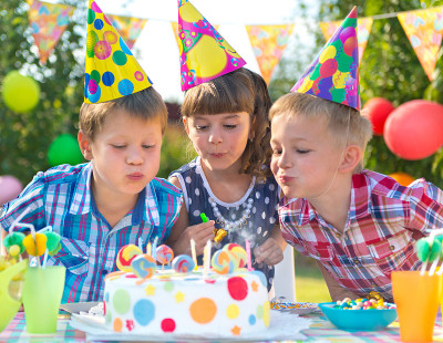 孩子们在生日聚会上吹蜡烛在蛋糕上