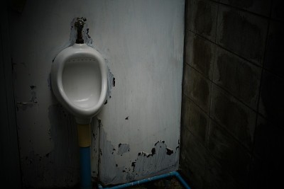 肮脏、破旧的小便池
