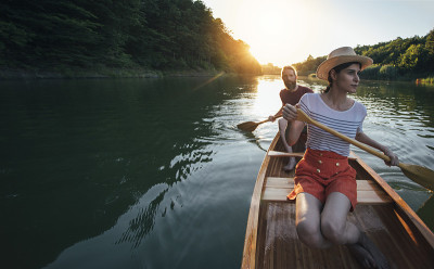 情侣们在夏日日落的湖面上划船