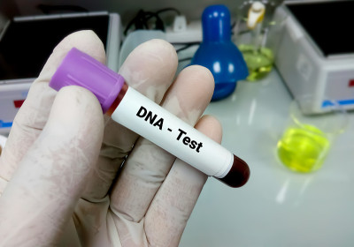 DNA测试。医生/科学家在实验室拿着用于DNA测试的血样采集管。