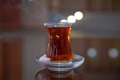 阿塞拜疆传统armudu玻璃杯中的茶。阿塞拜疆红茶与复古的白色桌子。土耳其红茶梨形玻璃，传统阿塞拜疆