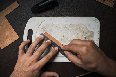 一个男人的手切割一张软木塞的俯视图。