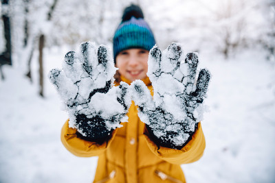 戴着手套的女孩被雪覆盖
