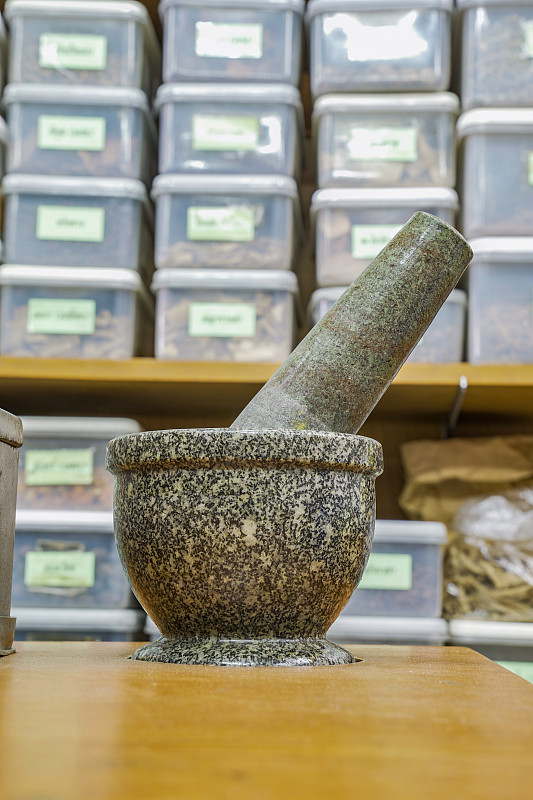 复古砂浆在草药店模糊草药货架后面，泰国。