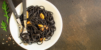 意大利面、墨鱼黑意面(海鲜、贻贝)的顶级菜单概念。食品的背景。本空间