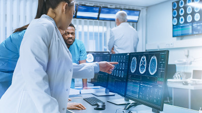 不同的医学科学家团队解决问题并指出电脑屏幕显示CT, MRI扫描。在大脑研究实验室工作的神经学家/神
