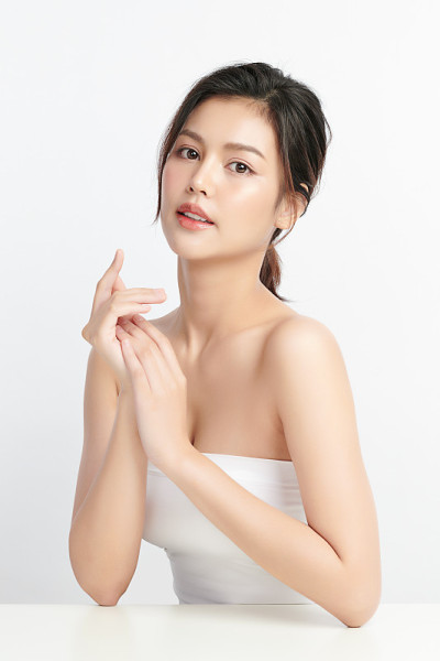 美丽年轻的亚洲女性与干净的新鲜皮肤在白色的背景，面部护理，面部治疗，美容和水疗中心，亚洲女性肖像。