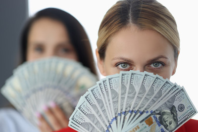 女人手里拿着百元大钞。