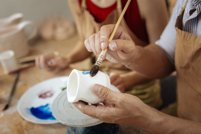 男陶工拿着画笔在装饰陶罐