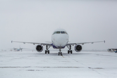 暴风雪中飞机在跑道上。飞机在大雪中滑行。飞机在下雪的机场。现代双引擎客机在暴风雪期间在机场滑行准备起