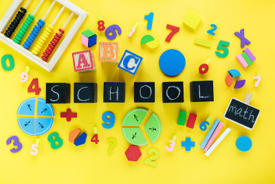 彩色数学分数在黄色背景。桌子上写着“学校”的积木。对孩子来说很有趣的数学。教育，回到学校的观念