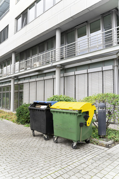 两个塑料清洁垃圾容器黑色和黄绿色分别用于分类垃圾