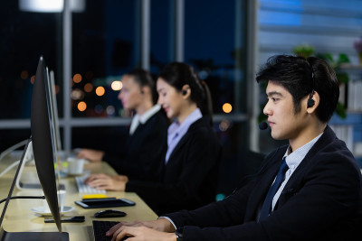 与同事团队在呼叫中心办公室加班到深夜。