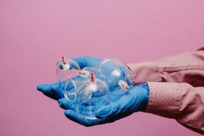 真空泵和罐的hijama。武器。在粉红色的背景上