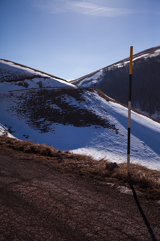 在意大利翁布里亚的诺尔恰Castelluccio di Norcia到达路上的雪地上的路标