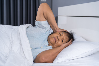 患有失眠症的老妇人正试图在床上睡觉