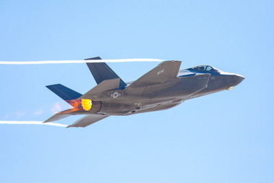 F-35闪电II在高g机动，加力燃烧器和冷凝尾在机翼边缘
