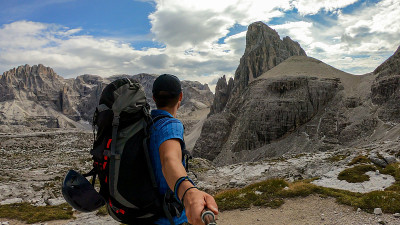 Oberbachernspitze——一名男子在意大利白云石徒步旅行时自拍。他有一个大背包。