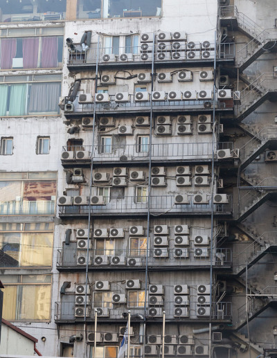 附在建筑物外墙上的空调室外机。