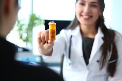 女药师手持一罐药丸和