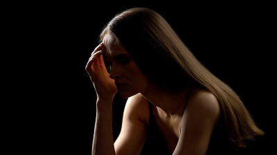 孤独的女人抱着头，忍受着偏头痛和压力，问题