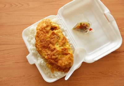 用塑料勺放在泡沫盒里的米饭煎蛋卷