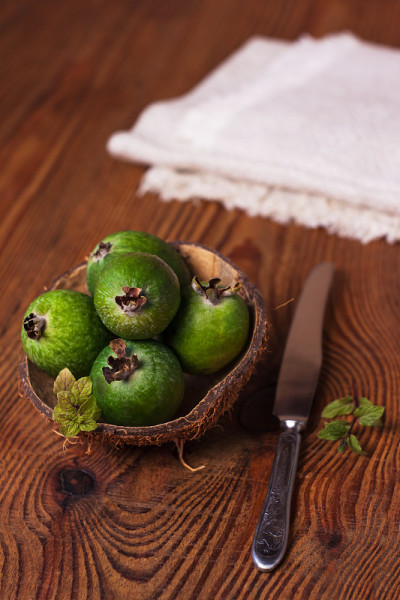椰壳壳上的青feijoa木背景。成熟的热带水果，生的素食。维生素c拷贝空间。