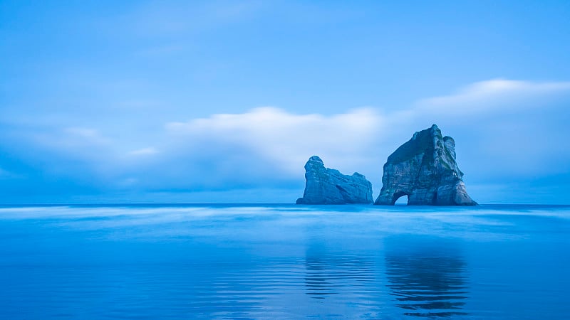 新西兰南岛，码头海滩上的拱门岛的全景。