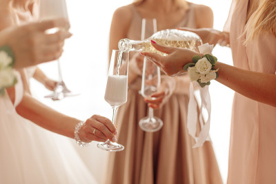 拿着满瓶香槟酒、穿着礼服的陌生女人。高的社会。庆祝、庆典、婚礼的概念。