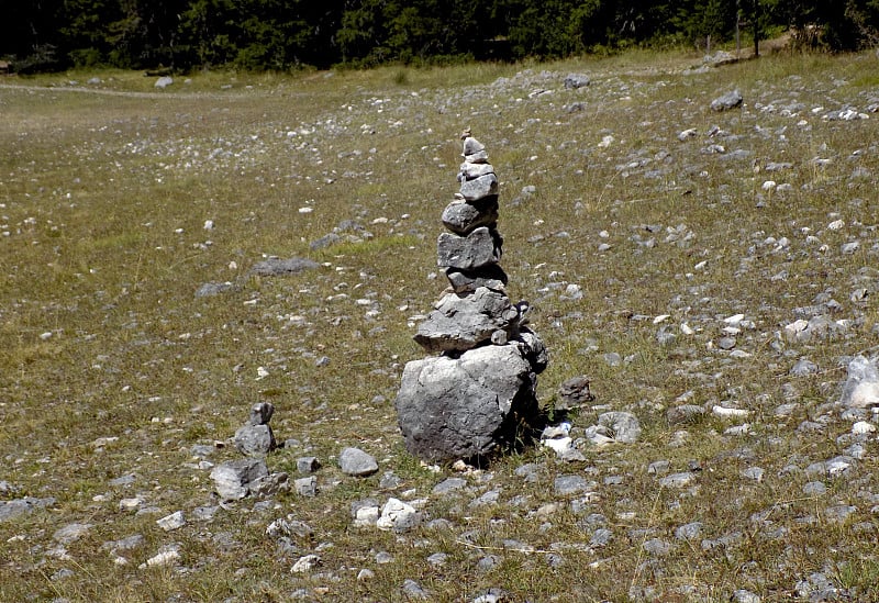 湖边山上草地上的石塔