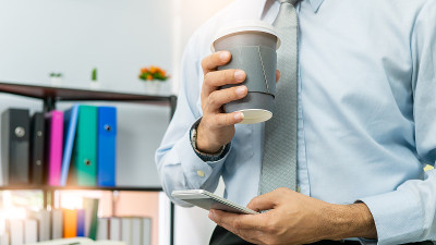 专业的商务人士手持在纸杯玻璃杯中喝新鲜的咖啡早上清爽的咖啡休息前工作会议电脑智能手机手机