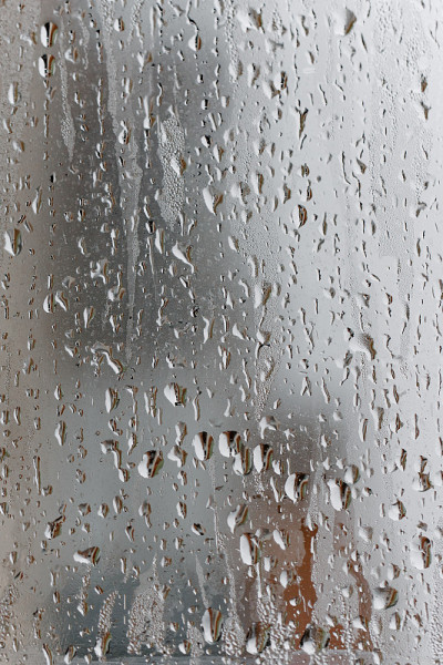 凝结在透明的玻璃窗上，水珠，雨。空气湿度高的窗户玻璃。自然水凝结的背景