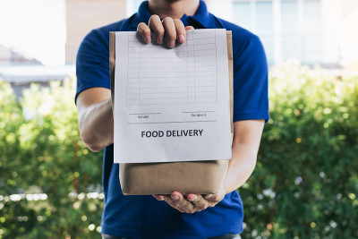 送货员正在给顾客送食品包装。