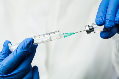 NHS医疗实验室技术人员插入注射器针头玻璃小瓶的护士